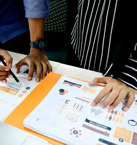 Analystes examinant des infographies et graphiques de données imprimés